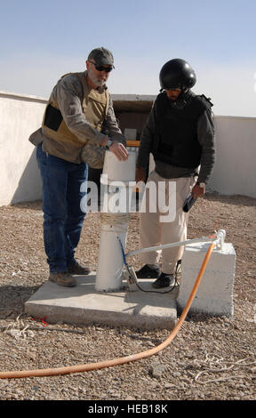 Während der Inspektion einer neuen medizinischen Klinik in der Bakwa Bezirk von Farah Provinz, inspizieren Afghanistan, Darren Richardson, das US Department of Agriculture (USDA) Berater für die Farah Provincial Reconstruction Team (PRT), und Hekmatullah Nazari, einer Vereinigung für ländliche Entwicklung (ARD) Vertreter der PRT auf der Reise begleitet eine kürzlich installierte Pumpe außerhalb der Klinik Eingang bei einem Besuch am 14. Februar , 2010.  Das PRT geförderte Bauvorhaben ist fast abgeschlossen.  "Seit unserem letzten Besuch vor ein paar Wochen, der Auftragnehmer und sein Team eine Menge Fortschritte in einem Shor habe Stockfoto