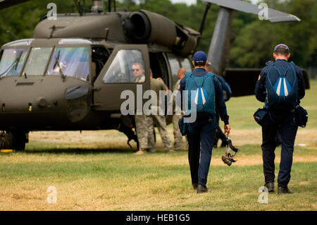 Nähern Sie jüngsterer Sohn Jesse Galt (links) und US Air Force Lieutenant Colonel Scott Drinkard, beide Mitglieder der US Air Force Academy Flügel von blau springen Mannschaft, US Army UH-60 Black Hawk Hubschrauber vor einer Demonstration 27 Juli. Die Flügel des blauen Fallschirm Team agiert als 98. Flying Training Squadron in der US Air Force Academy in Colorado Springs, Colorado, und zur Unterstützung der Boy Scouts of America 2010 National Scout Jamboree durchgeführt. Stockfoto