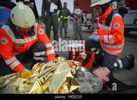 Bemühungen zur Betreuung von verletzten von einem simulierten Flugzeugabsturz während eines schweren Unfalls Antwort Trainings auf Ramstein Air Base, Deutschland, 18. Oktober 2014 unterstützen Host Nation Medizintechniker. Mitglieder der US Air Force und Host Nation Agenturen eine Partnerschaft bei der Durchführung einer Reaktion und die Wiederherstellung Übung in Vorbereitung auf mögliche reale Vorfälle. Senior Airman Hailey Haux) Stockfoto