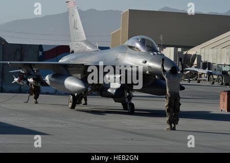 Ein US Air Force Airman taxis eine f-16 "Fighting Falcon" mit der 100. Expeditionary Fighter Squadron "Red Tails" Bagram Airfield, Afghanistan 7. August 2014. Die Mission des f-16 "Fighting Falcon" hier soll taktische Luft-Luft- und Luft-Boden-Operation Enduring Freedom zu unterstützen.  Das Gerät ist aus der 187. Kämpfer-Flügel in Montgomery, Alabama bereitgestellt.  Staff Sgt Evelyn Chavez Stockfoto