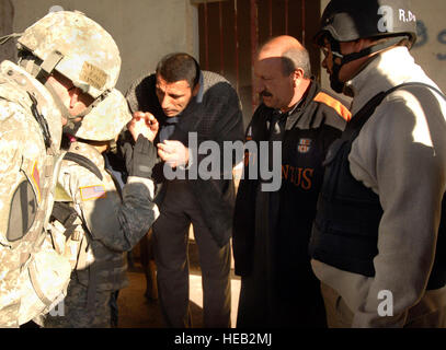 Hermosa, S.D., native Army Lieutenant Colonel Harvey Fitzgerald, links, ein senior Landwirtschaft-Business-Berater für die eingebetteten provinzielle Rekonstruktion Team 5 in Bagdad, 1st Brigade Combat Team, 1. Kavallerie-Division und Robert Dose, Recht, Inma Agribusiness Programmkoordinator, befestigt treffen und besprechen den Anbau von Datteln mit ein lokaler Unternehmer auf dem Markt in Taji, Irak, November 27. (Foto/techn. Sgt. William Greer, USAF) Stockfoto