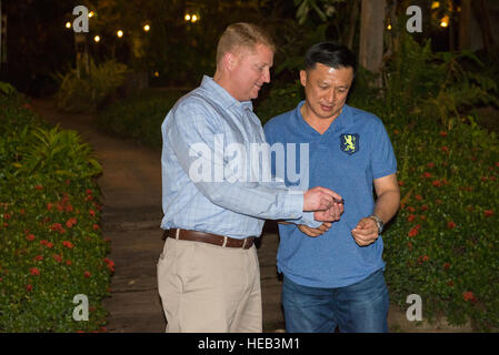 US Air Force Colonel William Freeman, 353rd Special Operations Group Kommandant Münzen Royal Thai Air Force General Group Captain Tanaset Thamamnuaykij, 23. Wing Air Combatant Command Kommandeur eines Abends nach dem Training Gold Cobra in Udon Thani, Thailand, 18. Februar 2016. Jemandem eine Herausforderungsmünze ist ein Weg des Respekts und wurde als ein Zeichen der Wertschätzung nach gemeinsam für zwei Wochen gegeben.  Senior Airman Stephen G. Eigel) Stockfoto