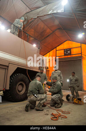 Feuerwehrleute aus der 376th Expeditionary Bauingenieur-Geschwader demonstrieren Techniken zu Oberst John Vaughn, 376th Air Expeditionary Wing stellvertretender Kommandant, Werkzeuge bis hin zu erhöhten Transit Center am Manas, Kirgisistan, 5. Februar 2014 transport eingesetzt. Die Feuerwehrleute statt eine Fortbildungsveranstaltung hier wo zeigten sie Vaughn Methoden zur Vorbereitung und Ausführung Brandbekämpfung und Rettungsaktionen. Senior Airman George Goslin) Stockfoto