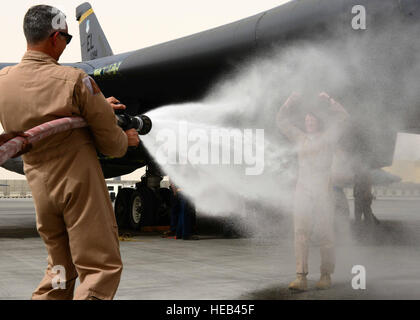 US Air Force Major General Roger H. Watkins, 379th Air Expeditionary Wing Commander, sprüht Oberst Jennifer Fullmer, 379th AEW-Vize-Kommandeur nach einem Fini Flug auf Al Udeid Air Base, Katar, 11. Mai 2013. Die USAF hat eine Tradition, wo sind Besatzungen an der Fertigstellung des letzten Flug in einem Flugzeug mit Wasser von ihren Kameraden abgespritzt bevor Sie geröstet werden. Watkins ist aus Fort Worth, Texas. Fullmer stammt aus Wilton, Connecticut  Staff Sgt. Ciara Wymbs) Stockfoto