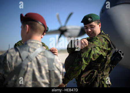 Ein Fallschirmjäger aus der 173. Infantry Brigade Combat Team (Airborne) tauscht Einheit Flecken mit einem Soldaten aus der litauischen Armee auf Luftbasis Siauliai, Litauen, 26. April 2014. Flieger aus die 37th Airlift Squadron transportiert 150 Fallschirmjäger von Aviano Air Base, Italien, Litauen auf Antrag der Wirt Nationen in der Region und weitere US-Engagement für NATO. Staff Sgt Sara Keller) Stockfoto