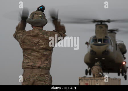 Ein Soldat aus 526th Brigade Support Battalion, 2nd Brigade Combat Team, laden 101st Airborne Division (Air Assault) Führer Piloten aus der 40. Combat Aviation Brigade in Platz zu Schlinge ein Frachtcontainer zu ihren Chinook-Hubschrauber Aug. 11 im Camp Buehring, Kuwait. Schlinge Ladevorgänge können US Army Central, Artillerie und LKW für den mobilen Einsatz im Nahen Osten zu bewegen.  Sgt. Brandon Hubbard, USARCENT Public Affairs) Stockfoto