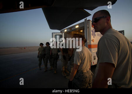 Mitglieder aus der 451st Expeditionary Aeromedical Evakuierung Squadron Ablösung 1 Contingency Aeromedical Staging Anlage warten, eine verwundete Marine aus einen Krankenwagen und auf eine c-130 Hercules in Camp Bastion, Afghanistan zu entladen. Die CASF Team ist verantwortlich für die Betreuung und den Transport von Patienten aus dem staging-Anlage und Rolle Krankenhaus auf Flugzeuge, die dann auf die nächste Stufe der medizinischen Versorgung transportiert werden. Master Sgt. Adrian Cadiz)(Released) Stockfoto