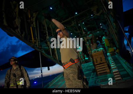 Senior Airman Cyril McKenney, 451st Expeditionary Aeromedical Evakuierung Squadron Ablösung 1 Contingency Aeromedical Staging Facility Luft-und Medizintechniker, leitet CASF Mitglieder, welcher Reihenfolge verwundete Marines auf eine c-130 Hercules in Camp Bastion, Afghanistan zu laden. Die CASF Team ist verantwortlich für die Betreuung und den Transport von Patienten aus dem staging-Anlage und Rolle Krankenhaus auf Flugzeuge, die dann auf die nächste Stufe der medizinischen Versorgung transportiert werden. Airman McKenney wird bereitgestellt von der 633rd medizinischen Operations Squadron, gemeinsame Basis Langley-Eustis, Virginia  Master Sergeant Adrian Cadiz) Stockfoto