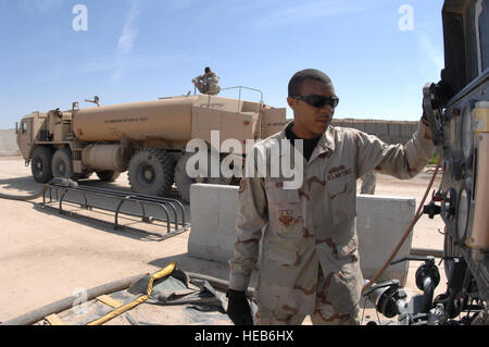 US Air Force Staff Sgt Edward Mims beobachtet die Messgeräte auf einem R-14 auftankenden System, wie er eine Armee Hemitt tankt, während US Army Spc. John Goughenour die Höhe gepumpt überwacht, 5 April, bei Kirkuk Regional Air Base, Irak. Die Armee Hemit ist zu anderen Forward operating Bases von Konvois eskortiert. Mims ist ein Brennstoffe Supervisor mit 506. Expeditionary Logistik-Bereitschaft-Geschwader und Goughenour ist ein Mitglied der Alpha Company, 325. BSB Schofield Barracks, Hawaii. Stockfoto