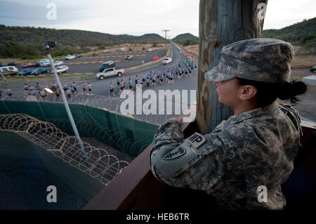 PFC. Kelly Cardenas, mit der Rhode Island National Guard 115. Militärpolizei Co., Uhren von einem Aussichtsturm in Camp Delta als Soldaten mit der 525th Military Police Battalion beteiligen sich an einer Formation bei Joint Task Force Guantanamo, 7 Juli laufen. Die 525th MP-Bataillon und der 115. MP Co. bietet einen Teil der Wache Kraft in JTF Guantanamo. JTF Guantanamo bietet sichere, humane, legale, transparente Pflege und Obhut der Gefangenen, einschließlich der Militärkommission und die verurteilten freigegeben von einem Gericht angeordnete. Die JTF führt Intelligenzansammlung, Analyse und d Stockfoto