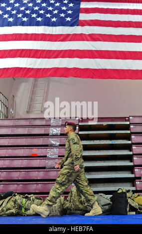 Ein Soldat, 23d Ingenieur Unternehmen zugewiesen Spaziergänge unter eine amerikanische Flagge auf Buckner Physical Fitness Center auf der gemeinsamen Basis Elmendorf-Richardson während einer Umschichtung Zeremonie.  Fast 100 Soldaten der US Army Alaska hat Donnerstagabend, 14. März von eine Neun-Monats-Bereitstellung in die südlichen Provinzen von Afghanistan zur Unterstützung der Operation Enduring Freedom zurückgekehrt. Die Soldaten sind das 23. Ingenieur-Unternehmen, Teil der 2. Ingenieur-Brigade nach Hause basiert auf der gemeinsamen Basis Elmendorf-Richardson zugeordnet. Während ihres Einsatzes durchgeführt die Soldaten gefährliche Route-Clearance Missionen um Impro entfernen Stockfoto