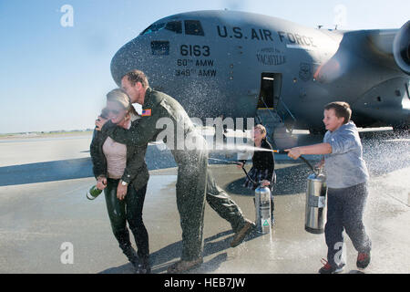 Kol. Corey Martin, 60. Air Mobility Wing Commander, erhielt eine warme, aber nassen willkommen von seiner Frau und seinen Kindern nach Abschluss seiner "Fini-Flug" an Travis Air Force Base, Kalifornien, 17. Februar 2015. Martin ist seit August 2014 der Wing-Commander und wird in Kürze seine neue Aufgabe in Südkorea beginnen. Ken Wright) Stockfoto