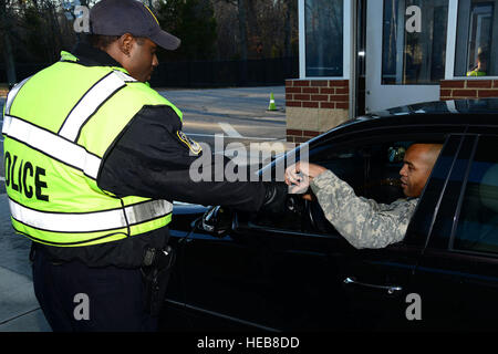 Officer Kawaun Thomas, 733rd Sicherheit Kräfte Squadron Polizist, prüft die IDs der eingehenden Personal in Fort Eustis, Virginia, 18. Dezember 2013. Die 733rd SFS besteht aus zivilen Militärpolizei und Soldaten aus den 221st und 3. Militärpolizei Abteilungen, einschließlich militärischer Arbeitshund Handler. Thomas ist ein Eingeborener von Brooklyn, N.Y.  Staff Sgt Ashley Hawkins Stockfoto