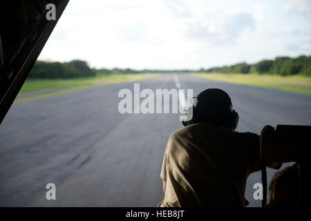 Senior Airman Calvin Cox, 75. Expeditionary Airlift Squadron C-130J Super Hercules Loadmaster leitet der Pilot das Flugzeug zurück Rollen zwar 21. Juni 2014, in Ost-Afrika. Die C-130J-Crew war Transport von Personal und Ausrüstung zur Unterstützung kombiniert Joint Task Force-Horn Afrikas Mission der Stabilisierung und Stärkung der Sicherheit in Ostafrika.  Senior Airman Riley Johnson) Stockfoto