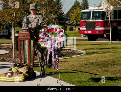 Senior Airman Bryan Schwinn, 92. Bauingenieur-Geschwader Feuerwehrmann klingelt eine zeremonielle Feuerwehrmann bei einem Retreat Festakt auf der Fairchild Air Force Base in Washington, 11. September 2015. Traditionell drei Glocken sind solide in Erinnerung an diejenigen, die nicht mehr auf den Anruf wegen der 11. September 2001, Tragödie vor 14 Jahren reagieren können. Airman 1st Class Taylor Bourgeous) Stockfoto