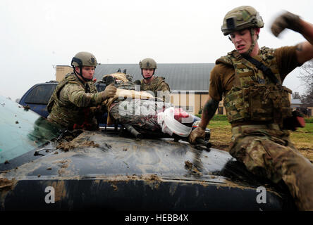 Drei Teams der vier Flieger transportieren Simulationspatienten über eine Fahrzeuge und dabei einen Blick heraus für feindliches Feuer während einer Übung Tactical Combat Casualty Care auf der Scott Air Force Base, Ill., 4. Dezember 2014. Das Ziel des Teams war, dass zwei ihrer Patienten an eine Stelle bekommen wo sie zu einer höheren Ränge der Pflege transportiert werden würde. Die Teams alle Flieger mit dem 375-jährigen Air Mobility Wing und 932nd Airlift Wing Explosive Ordnance Flüge zusammengesetzt hatte vier Rollen, Sanitäter, Arzthelferin, Teamleiter und ein Sicherheits-Mitglied. Stockfoto