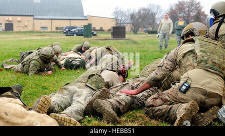 Explosive Ordnance Flieger verwenden Sie einen niedrigen Crawl zu transportieren Schauspielpatienten aus Feind Feuer während einer Übung Tactical Combat Casualty Care auf der Scott Air Force Base, Ill., 4. Dezember 2014. Die Teams alle Flieger mit dem 375-jährigen Air Mobility Wing und 932nd Airlift Wing Explosive Ordnance Flüge zusammengesetzt hatte vier Rollen, Sanitäter, Arzthelferin, Teamleiter und ein Sicherheits-Mitglied. Es gibt drei Teile, TCCC, unter Feuer, taktischen Bereich Care und taktische Evakuierung Care Pflege. Schüler lernen, wie man drei Hauptursachen von potenziell survivable Schlachtfeld Verletzungen zu identifizieren – Hemorrha Stockfoto