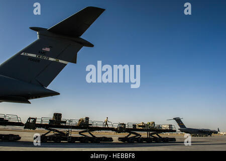 US Air Force Antenne Port Spezialisten, zur 451st Expeditionary Logistik Bereitschaft Squadron versetzt, entladen Fracht aus einer c-5 Galaxy Frachtflugzeugen 6. März 2013, Kandahar airfield, Afghanistan. Sie sind gemeinsame Expeditionary beauftragt Flieger mit dem 466th Air Expeditionary Geschwader. JET-Piloten sind mit Luftwaffe und Armee Einheiten an rund 80 Standorten in ganz Afghanistan zu kritischen Fähigkeiten und dynamische Führung Staff Sgt Marleah Miller eingebettet) Stockfoto