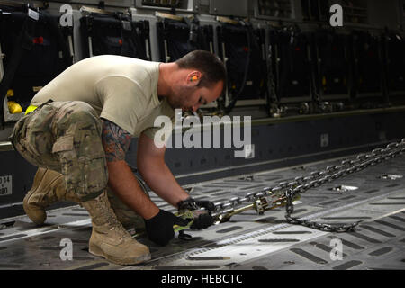 US Air Force Senior Airman Jerry Hullette, gebürtig aus Lincolnton, N.C. und Spezialist für Rampe zur 455. Expeditionary Luft Port Squadron versetzt strafft die Kabel, die eine erweiterte Mobilität LKW an Bord einer c-17 Globemaster III in Bagram Air Field, Afghanistan 20. Juli 2014 einrastet. Flieger, 455 EAPS arbeitete mit einer c-17-Mannschaft sechs afghanische ambulante Fahrzeuge entlasten und hochladen zwei HEMTT Fahrzeuge zugewiesen. Hullette wird von der 436th Antenne Port Squadron der Dover Air Force Base, Del. (US Air Force Foto von Master Sgt. Cohen A. Young/freigegeben) bereitgestellt. Stockfoto