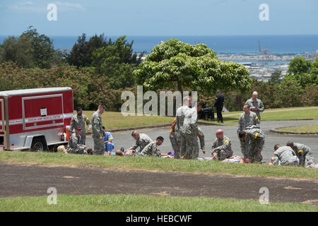 Tripler Army Medical Center Personal zu stabilisieren und selektieren transportiert simulierten Unfall während humanitäre Hilfe und Katastrophenhilfe (HA/DR) als Teil des Randes der Pazifik (RIMPAC) Übung 11. Juli 2014, über Honolulu ausüben. Der Zivilist, Gelenk- und Koalition HA/DR Aufwand erstreckte sich über 20 Kliniken und fünf Inseln, wo die Teilnehmer auf Reaktion, Koordination und Durchführung während einer simulierten Kategorie 3 Hurrikan getestet wurden.  Zweiundzwanzig Nationen, 49 Schiffe und sechs u-Boote, mehr als 200 Flugzeugen und 25.000 Mitarbeiter beteiligen sich an RIMPAC vom 26. Juni bis Aug. 1 in und aro Stockfoto