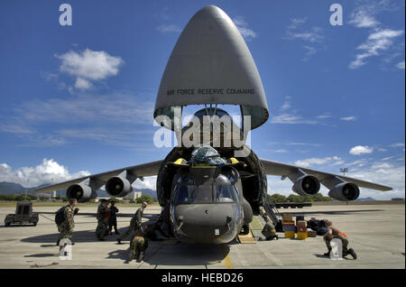 HICKAM AIR FORCE BASE, Hawaii - Flieger und Soldaten laden einen CH-47 Chinook Schwergut Hubschrauber auf einer c-5 Galaxy hier. Unternehmen B, 214th Aviation Regiment des 2. Bataillons, 25. Aviation Regiment am nahe gelegenen Wheeler Army Air Field, erhielt Aufträge zur Bereitstellung 60 Soldaten, vier Hubschrauber und support Ausrüstung nach Pakistan Erdbeben Hilfsmaßnahmen zu unterstützen. Eine Gesamtkraft Team hier half das Flugzeug 16 Okt. laden. (Foto: U.S. Air Force Tech Sergeant Shane A. Cuomo) Stockfoto