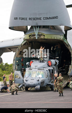 CAPE CANAVERAL AIR FORCE STATION, Florida,--Air Force Reservisten aus dem 920th Rettung Flügel Patrick Air Force Base, Florida, bereiten zwei HH - 60G Pave Hawk-Hubschrauber durch Faltung verschiedenen beweglichen Teile für den Transport in einem Flugzeug c-5 Galaxy.  Die c-5 gefolgen Helos auf der südlichen Wüste von Arizona wo Helikopter-Besatzungen und Wartungspersonal Juli 12-25 für die härtesten Flugbedingungen in der Welt - Afghanistan ausgebildet. Nicht nur ist das Land berüchtigt für schroffe Gelände, aber bekannt für improvisierte Staubstürme, keine kulturellen Beleuchtung und einige der höchsten Berge und steilsten Vall Stockfoto