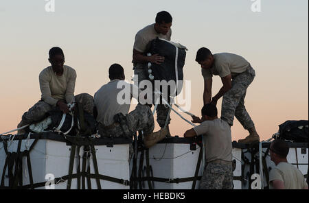 US Army Fallschirm Rigger vom 11. Quartiermeister, 82. Sustainment Brigade, 18. Airborne Corps von Fort Bragg, N.C., bereiten Sie Bündel von humanitärer Hilfe zu Luft fallen gelassen, 7. November 2014, im Irak. 121 Tonnen Nahrung, Wasser, Zelte, Kleidung, Bettwäsche, gestiftet von Hilfsorganisationen aus mehreren Ländern werden Luft Gedroppt von irakischen, australischen und US c-130 Hercules, Iraker, umgeben von Daesh Kämpfer zu unterstützen. (US Air Force Foto von Staff Sgt. Perry Aston/freigegeben) Stockfoto