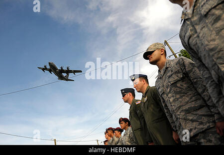 Eine US Luftwaffe C-130J Super Hercules fliegt über eine Formation der US Air Force Flieger wie sie zu einer Zeremonie marschieren an Veteranen des zweiten Weltkrieges zum 70. Jahrestag des d-Day, hier, 6. Juni 2014 zu erinnern. Die Veranstaltung war eine mehrere Gedenkfeiern zum 70. Jahrestag des d-Day-Operationen, die durch die Alliierten während des zweiten Weltkriegs 5. und 6. Juni 1944. Mehr als 650 US-Militärangehörige haben Truppen aus verschiedenen NATO-Staaten zur Teilnahme an Zeremonien zu Ehren der Ereignisse auf Einladung der französischen Regierung angeschlossen. http://www.EUCOM.mil/Key-activities/Featured-Events/d-Day-June-6-1944 (U Stockfoto