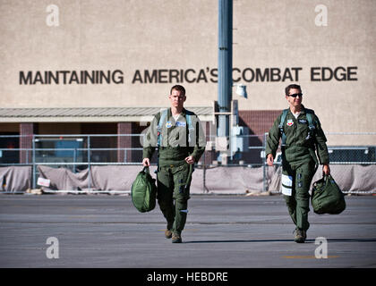 US Air Force Captain Jaxon Lee, 414th Combat Training Geschwader f-15 Eagle Pilot und Oberstleutnant Marc Mathes, 53. Test und Evaluation Group stellvertretender Kommandeur, Schritt in Richtung ihrer Flugzeuge während der Beschäftigung Missionsphase Übung, 7. Dezember 2012, auf der Nellis Air Force Base, Nevada Die mir-Phase, durchgeführt in der Nevada Test und Training, ist der Schlussstein Übung unter der Leitung von der US Air Force Weapons School. (U.S. Air Force Photo/Senior Airman Brett Clashman) Stockfoto