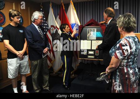 Bob McDavid, zweiter von rechts, der Bürgermeister von Columbia, Missouri, und US Army Lt. Col. Patricia George, center, der Kommandant der 11. Bataillon und der St. Louis Eingang Verarbeitung Militärstation, entdecken Sie ein Foto von Spc. Sterling Wyatt, seine Purple Heart, Bronze Star und seine Biographie während einer Einweihungsfeier in St. Louis 17. Juli 2014. Sterling wurde in Aktion getötet, als sein Fahrzeug durch eine improvisierte explosive Vorrichtung während einer Patrouille in der Provinz Kandahar, Afghanistan, 11. Juli 2011 getroffen wurde. (US Air Force Foto von Senior Airman Tristin Englisch/freigegeben) Stockfoto