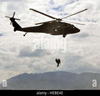 US Army Flug Medic zugewiesen, das 1. Bataillon, 228th Aviation Regiment, Joint Task Force-Bravo führt eine simulierte Rettung eines anderen US-Service Mitglied der Task Force aus den Wassern des Sees Yojoa, Honduras, während ein Overwater Hebezeug Trainingsübung mit einer Armee UH-60 Black Hawk Hubschrauber 25. Februar 2014 zugewiesen. Die Task Force führt gemeinsame, kombinierten und ressortübergreifende Operationen und Einsätze im gesamten zugewiesenen geographischen Bereich zur Erhöhung Theaterwide Betriebssicherheit und zur Stärkung der regionalen Zusammenarbeit unterstützt. (U.S. Air Force Photo von Capt Za Stockfoto