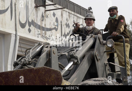 051107-F-2729L-017 Muzaffarabad, Pakistan (7. November 2005) Ð US Marine Equipment Operator Constructionman Ryan Smith, links, zugewiesen, Naval Mobile Bau-Bataillon sieben vier (NMCB-74), arbeitet in Verbindung mit einer pakistanischen Service-Mitglied, wie sie beschreibt Methoden, Ablagerungen an einem Standort in Muzaffarabad, Pakistan zu löschen. Die Vereinigten Staaten beteiligt sich eine Multi-nationale Unterstützung und Betreuungsaufwand von der pakistanischen Regierung geführt, um Hilfe für die Opfer des verheerenden Erdbebens zu bringen, die die Region am 8. Oktober 2005 erschütterte. Foto: U.S. Air Force Airman 1st Class Barry Loo (REL Stockfoto