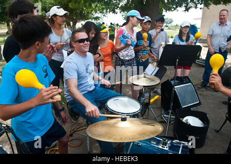 Senior Airman Simon Thomsen spielt Schlagzeug für Kinder der Kirgisischen Republik nach der US Air Forces Central Band "Vektor" Aufführung bei den Majak-Camp, Kirgisistan, 23. Juli 2012. Nach dem Konzert Vektor Bandmitglieder interagiert mit den Kindern und spielte verschiedene Instrumente mit ihnen. Thomsen ist ein Schlagzeuger aus der Kanalinseln Air National Guard Station, Calif., bereitgestellt und stammt aus Los Angeles. Stockfoto