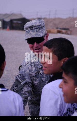 US Army Lt. Col Timothy Bush aus Toledo, Ohio, Kommandeur der 2. Brigade, 20. Feldartillerie-Regiment, 41st Fires Brigade, Forward Operating Base Delta, Irak, begrüßt Studenten aus Al Ezdehar Grundschule am 22. Mai um gemeinsame Sicherheit Station 2 (Al Ezdahar), Shayk Sa'ad, Irak. Stockfoto