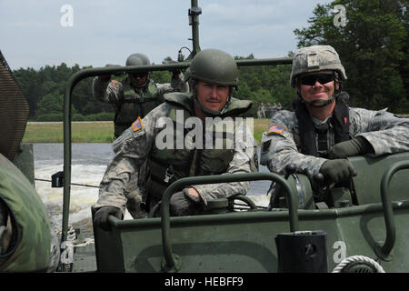 U.S. Army Sergeant Chris Williams (R) und Spc. Chris Poe des ersten Zuges, 299. Engineering Company von Fort Belvoir, Virginia, betreiben ein Mark II Brücke errichten Boot während des Transports der HUMVEES auf ein improvisierter Ribbon Bridge während Übung WAREX/Global Medic 2013 bei Fort McCoy, Wisconsin, USA, 20. Juli 2013. Globale Medic, in Verbindung mit WAREX, übt sich jährliche Gelenk-Reserve Feld-Training entwickelt, um alle Facetten der Bekämpfung Theater aeromedical Evakuierung Unterstützung zu replizieren.  (US Air Force Foto von Master Sgt Roy Santana/freigegeben) Stockfoto