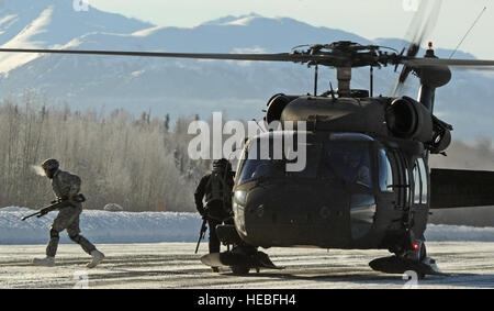 Eines US-Soldaten des 1. Bataillons, 501st Fallschirm-Infanterie-Regiment zugewiesen läuft 4. Infantry Brigade Combat Team, 25. Infanterie-Division, U.S. Army Alaska Weg von einem UH-60 Black Hawk-Hubschrauber mit einem M107.50 Kaliber Langstrecken Scharfschützengewehr nach Eingriff Ziele aus einer Hubarbeitsbühne im Hubschrauber über der Malamute-Drop-Zone am gemeinsamen Basis Elmendorf-Richardson, Alaska, März 7 , 2014. (US Air Force Foto von Justin Connaher/freigegeben) Stockfoto