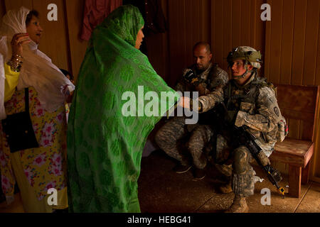 Rollenspieler als afghanischer Dorfbewohner express es Bedenken zur US Armee Sgt. Victoria Shapiro, eine weibliche Engagement Teammitglied zugewiesen Charlie Kompanie, 1. Bataillon, 14. Infanterie-Regiment, 2nd Stryker Brigade Combat Team, 25. Infanterie-Division, in einem nachgebauten afghanischen Dorf, 5. Februar 2013, während Krieger Speer an Schofield Barrack in Wahiawa, Hawaii ausüben. Weibliche Engagement Teams gehen wo Infanterie Männer nicht. Teams von weiblichen Soldaten Infanterie Missionen beimessen und sorgen für die notwendige Unterstützung bei Such-und Freiraum. In vielen Teilen Afghanistans, wo Interaktionen zwischen den Vereinten Nationen Stockfoto