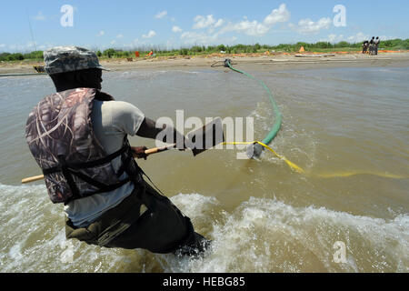 Pvt. Richard Jones, der Haynesville, Louisiana, mit der Louisiana Nationalgarde 528th Engineer Battalion, bewegt sich das Saugrohr für eine Wasserpumpe, die verwendet wird, um Tiger Dam Abzweigung Wassersystem, 20. Mai 2010, in der Nähe der südwestlichen Pass des Mississippi River Delta aufzublasen. Die 1023rd VEC baut eine 7,1 Meilen Barriere verhindern, dass mögliche Öl kommen in den Feuchtgebieten. Stockfoto