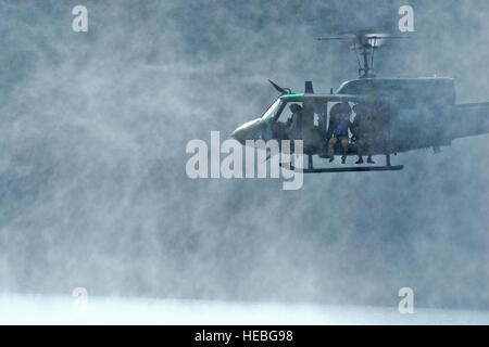 Ein UH-1N Iroquois schwebt 10 Fuß über dem Wasser auf der Suche nach einer möglichen Landezone im Wasser Betrieb Ausbildung 17. Oktober 2014, am Long Lake, Washington Während der Ausbildung rezertifiziert Piloten und Flugpersonal Ingenieure aus der 36. Rettungsflug Fairchild Air Force Base, Washington, auf Rettung Betrieb Wasserprozeduren. 36. RQF unterstützt die US Air Force Survival School Ausbildung durch praktische Hubschraubereinsätze für mehr als 3.000 Studierende pro Jahr. (US Air Force Foto/Staff Sgt. Alexandre Montes) Stockfoto