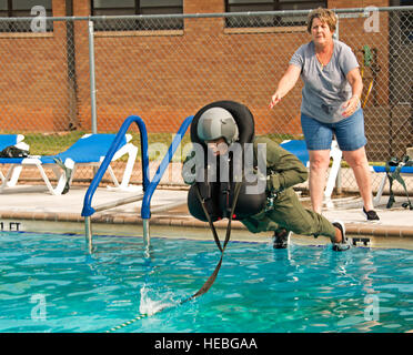 Laura Silver, 80. Operation Support Squadron stabilisieren Capt Brandon Bailey, 459th Flying Training Squadron Euro-NATO Joint Jet Pilot Training Fluglehrer, bevor er von einem Flaschenzug betriebenen Kursleiter als Bestandteil der Fortbildungsmaßnahmen Wasser überleben, 28. August 2015 in der Sheppard Air Force Base, Texas, Basis Pool gezogen wird. Die Ausbildung wird ein Fallschirm Wasserlandung nach dem Auswerfen aus einer t-38 Talon Flugzeug simuliert.  (US Air Force Foto von Danny Webb/freigegeben) Stockfoto