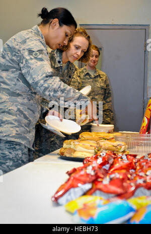 Senior Airman Vikki Flores und Oberstleutnant Sirena Morris auswählen welche Sandwich zu essen, während die Frauen Gleichheit Day Feier auf der 379th Air Expeditionary Wing in Südwestasien, 26. August 2013. Flores ist ein 379th Expeditionary Bauingenieur-Geschwader Notfallmanagement Geselle aus Dover Air Force Base, Delaware, und eine Azusa, Kalifornien, native bereitgestellt. Morris ist der 379th Expeditionary Kraft unterstützen Staffelkapitän und ein Fayetteville, NC, native. (U.S. Air Force Photo/Senior Airman Benjamin Stratton) Stockfoto