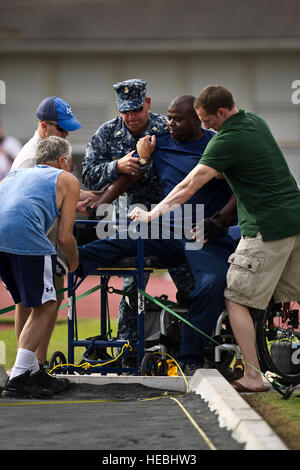 Freiwillige mit Navy Wounded Warrior Safe Harbor unterstützen im Ruhestand US Coast Guard Lt. Sancho Johnson in einer Sitzung Kugelstoßen Position für ihn in der ersten konkurrieren immer Verwundeten Krieger pazifischen Studien im Stadium Iolani School Kozuki 15. November 2012, in Honolulu, Hawaii. Verwundeten, Kranken und verletzten Seeleute und Küste Gardist vom ganzen Land gehen auf 2013 Krieger Spiele Marine-Coast Guard Team im Bogenschießen, Radfahren, Leichtathletik, schießen, sitzen Volleyball, Schwimmen und Rollstuhl-Basketball für einen der 35 Plätze. (Department of Defense Foto von US-Air Force Te Stockfoto