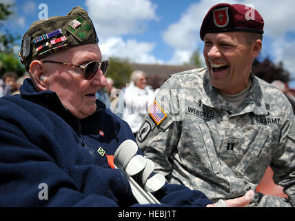 US Army Chaplian, Captain Jason Webster mit dem 1. Bataillon, 503. Infanterieregiment, 173. Infantry Brigade Combat Team (Airborne), Gespräche mit Curtis Phillips, ein US Armee-Veteran, der auf Utah Beach in der Normandie, mit Firma D der 22. Infanterie im zweiten Weltkrieg während einer Zeremonie zu Ehren den Dienst der US-Armee Krankenschwestern während des zweiten Weltkriegs gelandet , in Bolleville, Frankreich, 4. Juni 2014. Die Veranstaltung war eine von mehreren Gedenken an den 70. Jahrestag des d-Day Operationen durch die Alliierten während des zweiten Weltkriegs 5. und 6. Juni 1944. Mehr als 650 US-Militärangehörige sind Truppe beigetreten. Stockfoto