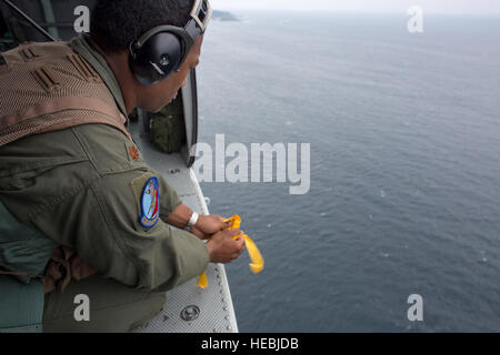 Generalmajor Zensaku Munn, 374th Operations Support Squadron Air Mobilität Verbindungsoffizier, Tropfen Meer Farbstoff markieren Sie einen Drop-Zone-Bereich in der Sagami-Bucht, Präfektur Shizuoka, Japan, 31. August 2014, während der Shizuoka umfassende Disaster Bohrer. UH-1N Irokesen Crew-Mitglieder gelöscht das Wasser Drop-Zone für eine c-130 Hercules Airdrop. (U.S. Air Force Photo von Osakabe Yasuo/freigegeben) Stockfoto