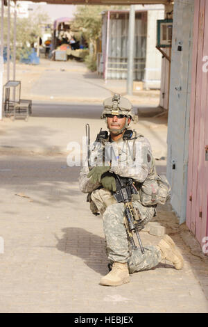 US Army Staff Sgt Niobel Santos von Kapolei, Hawaii, mit 3rd Platoon, Bravo Company, 35. Infanterie-Regiment, 2. Bataillon, 3. Brigade, 25. Infanterie-Division, zugewiesene Patrol Base Woodcock, kniet sich während der Durchführung von Sicherheit auf dem Prüfstand außerhalb des Mujamma Youth Center in Mujamma, Irak, Juli 11. Stockfoto