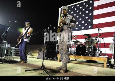 US Air Force Airman 1st Class Theodore Wilkins, bereitgestellt von Kadena Air Base, Okinawa, Japan, zur 732. Expeditionary Sicherheit Kräfte Squadron versetzt, spielt das Saxophon auf der Bühne bei einem Musikkonzert mit dem Grammy-Gewinner Rock-N-Roll Trio "Los Lonely Boys," am Kontingenz operative Basis Speicher, im Nordirak, Sept. 4. Stockfoto