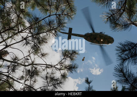 UH-N1-Hubschrauber-Crew-Mitglieder und Flieger aus dem 791st Rakete Sicherheit Kräfte Squadron taktische Reaktion Kraft während einer Such- und Rettungsmission Training in der Nähe von Garrison, N.D., 20. Juli 2015 zusammengearbeitet. Während des Trainings nahmen TRF Mitglieder Positionen in bewaldeten Standorten damit die Hubschrauberbesatzung lokalisieren sie üben konnte. Sobald diese gefunden ist, wurden die TRF-Mitglieder in das Flugzeug über eine Kraft-Penetrator gehisst. (U.S. Air Force Fotos/Senior Airman Stephanie Morris) Stockfoto