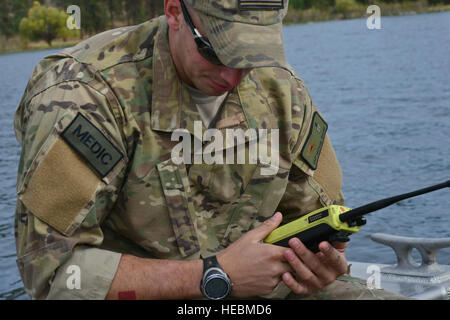 Staff Sgt Micahel Shamp, 336th Training Support Squadron unabhängige Pflicht Medizintechniker auf die "Entwarnung" im Wasser Betrieb Ausbildung von Piloten an Bord ein UH-1N Iroquois Hubschrauber 17. Oktober 2014, am Long Lake, Washington, 36. Rettungsflug zugewiesen wartet Shamp, begleitet von einem anderen unabhängigen Pflicht Medizintechniker, Staff Sgt Brittany Scott, waren im Standby-Modus auf einem Boot damit maximale Sicherheit vor , während und nach der Ausbildung Wasser-Operationen. Als unabhängige Pflicht medizinische Techniker sind sie die einzige medizinische Dienstleister im Notfall an der Nachricht eines Momentes. (U.. Stockfoto