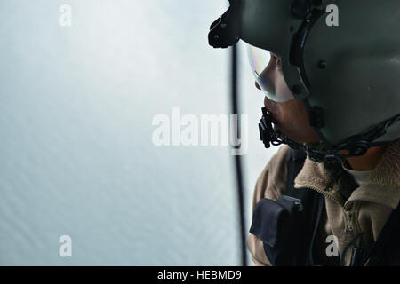 Staff Sgt Jeremy Bernite, 36. Rettungsflug Aircrew Flug Ingenieur, blickt die Bucht Tür ein UH-1N Iroquois Hubschrauber im Wasser Betrieb training Szenario für Bekämpfung Rettung Offiziere aus dem 336th Trainingsgruppe und 36. RQF Piloten 17. Oktober 2014, am langen See, Washington Aircrew Ingenieure gehen durch 25 Tage hartes Training bestehend aus Grundstudium, combat Survival Trainings, Wasser überleben , nicht Fallschirmspringen überleben und eine grundlegende Flugingenieur Kurs. Ingenieure erhalten Sie Örtlich festgelegtflügel oder Drehflügel Hubschrauber Flugzeugsysteme. Sie überwachen Hydraulik, Motorleistung bei cl Stockfoto