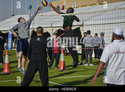 Qatar Emiri Air Force Mitglieder und Angehörige spielen ein freundliches Spiel der Volleyball im Qatar National Sports Day auf Al Udeid Air Base, Katar, 11. Februar 2014. Zum ersten Mal wurden mehr als 100 Soldaten, Matrosen, Soldaten, Marines und Zivilisten eingeladen, an der Veranstaltung teilnehmen, spielen Basketball, Fußball und Volleyball mit ihren Host Nation Gegenteile. Die Qatar National Sports Day ist eine Initiative angenommen im Jahr 2011 durch den aktuellen Emir, Scheich Tamim bin Hamad Al Thani, um weitere Werte des Sports in der Nation Kultur einbinden und inspirieren die Menschen gesund und greifen in physischen Akt sein Stockfoto